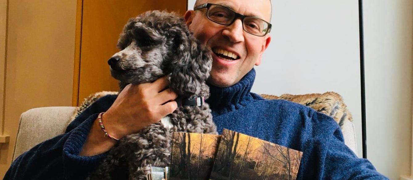 Maxim D. Shrayer holding poodle and two copies of book