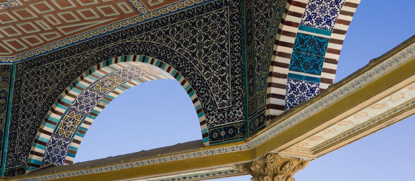 inside surface of decorative tiled ceiling against blue sky