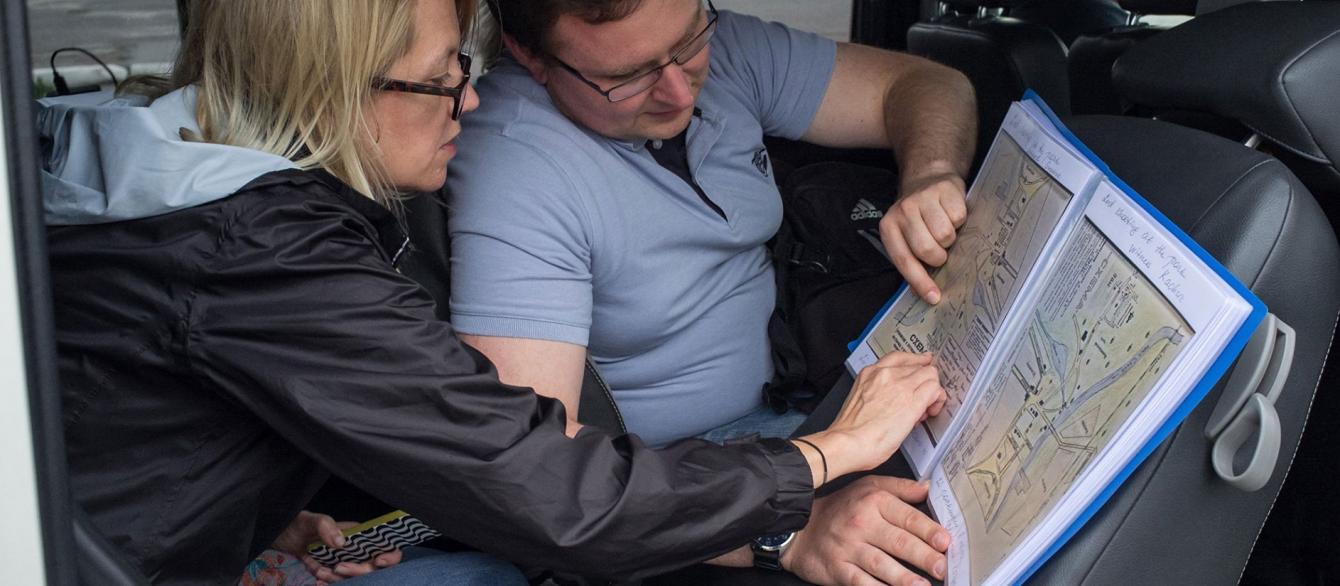Wendy Lower and her fellow pointing at the map in the car
